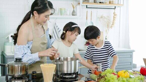 快乐的亚洲家庭在家里的厨房里一起做饭一起享受家庭活动