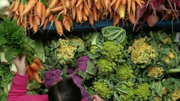在农贸市场农产品摊购买健康有机蔬菜的妇女