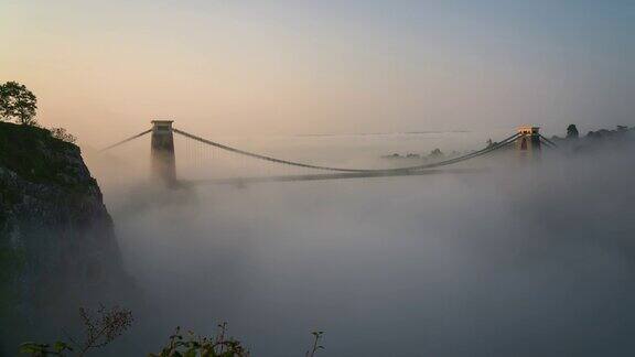 英格兰西南部布里斯托尔埃文河上的克利夫顿吊桥日出时雾气弥漫4k延时