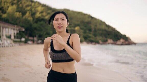 一个年轻女子在沙滩上慢跑的慢镜头