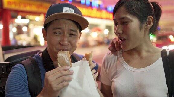 在泰国曼谷一对年轻的亚洲夫妇第一次吃泰国香酥煎饼