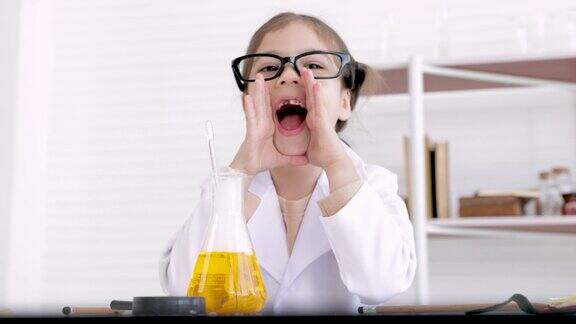 穿着白大褂制服在实验室里嬉笑的开朗小学生戴着眼镜在实验室里摆弄科学仪器的调皮学生带着儿童观念的化学实验教育