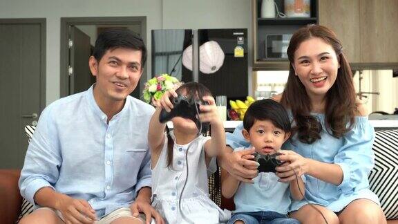 亚洲家庭两个孩子在看电视和玩游戏
