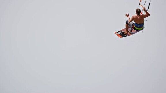 SLOMO男性风筝滑板者跳到空中做一个抓取