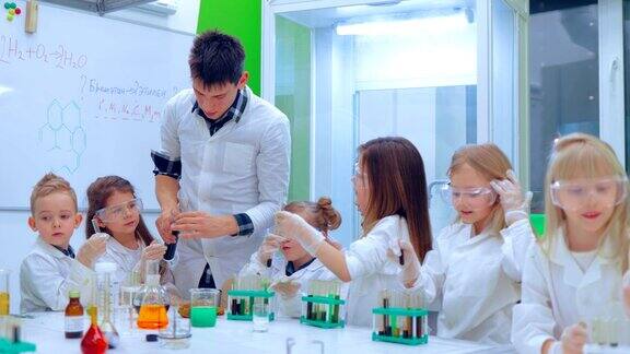 年轻的男孩和女孩们正在做化学实验老师和小朋友在上化学课