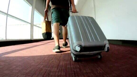 带着行李走过机场航站楼的男子旅客