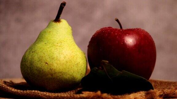 苹果和梨旋转梨和苹果在木制背景上接近秋收的苹果和梨4k剪辑