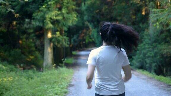 在森林小径上跑步的女人