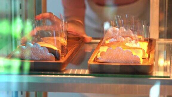 4K亚洲女咖啡店员工把蛋糕放在烘焙冰箱里