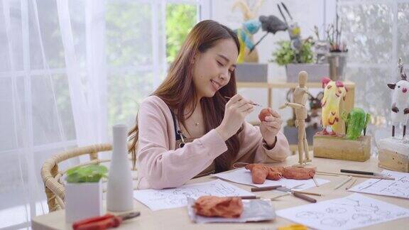 年轻的亚洲女孩在家里用黏土做雕塑爱好泥塑概念