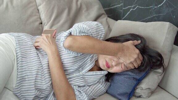 亚洲成熟女性躺在沙发上生病头痛偏头痛