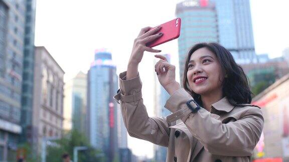 在中国成都的一个下午一个非常快乐的年轻亚洲女人用手机拍摄慢镜头