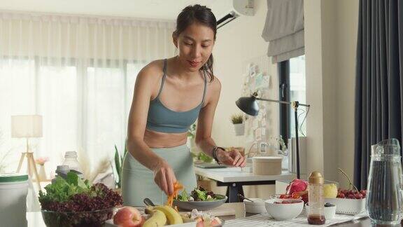 年轻的亚洲运动员在家里做沙拉饮食和健康食品