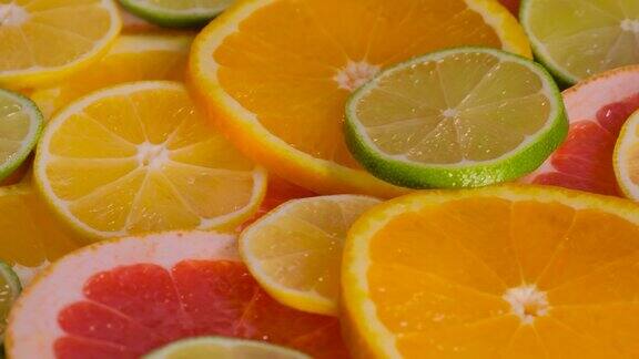 特写:旋转表面上的橙子、葡萄柚、柠檬和酸橙水果片