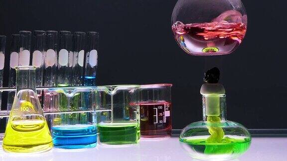 近距离酒精灯是煮沸的红色化学液体烧瓶与实验室玻璃器皿在黑色背景实验室研发理念