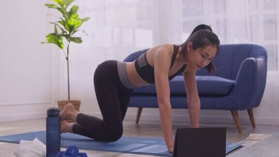 亚洲妇女在运动服装锻炼腿部锻炼和有氧运动在家里