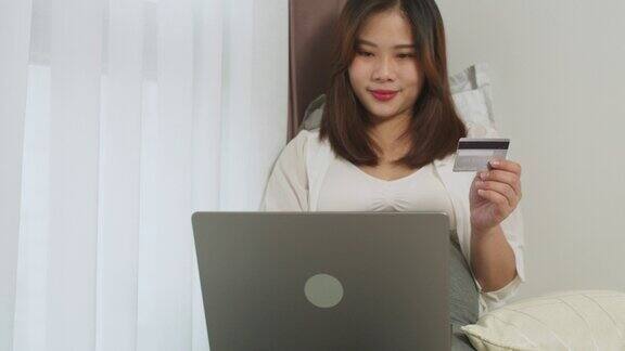 亚洲孕妇使用笔记本电脑在网上购物