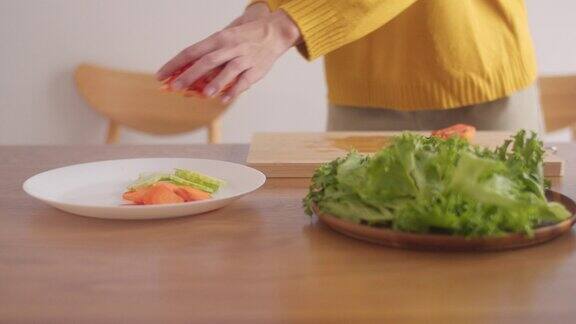 一名妇女在砧板上切西红柿的特写准备早上在家做沙拉的食物