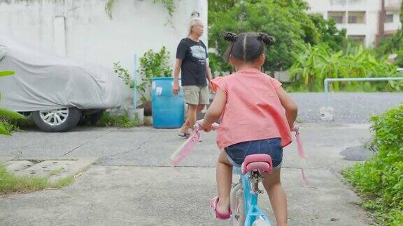 亚洲女孩和爷爷骑自行车