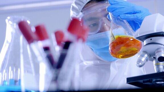 科学家穿着个人防护装备在实验室的试管中做一些研究检查一种液体