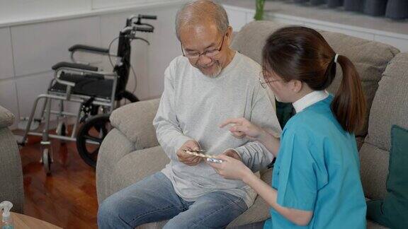 亚洲老年男性患者在敬老院与医生护士咨询处方药护工治疗师药剂师妇女在客厅里拿着药瓶药量在家里