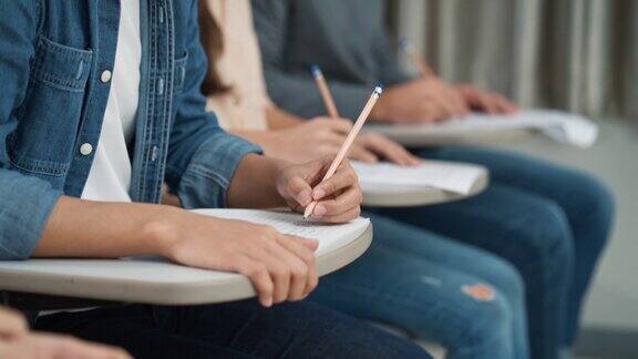 大学学生在教室里学习和写笔记的特写