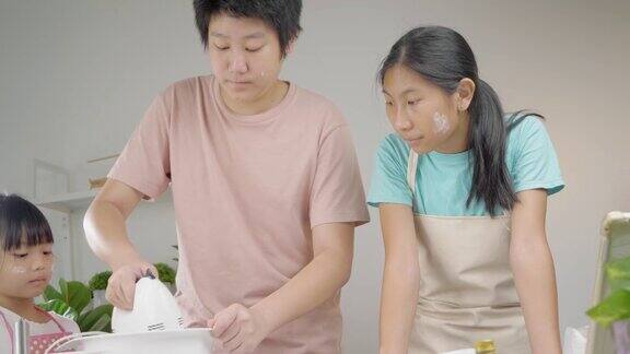 亚洲孩子在家里和姐姐一起拌面团做自制饼干生活理念