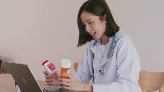 亚洲女医生正在用笔记本电脑与病人进行视频通话远程医疗