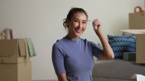 快乐的年轻亚洲女人展示新房子的钥匙