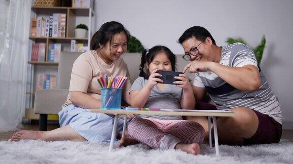 亚洲家庭一起在客厅玩智能手机游戏