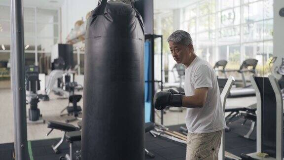 活跃的中国老年男子在健身房练习拳击