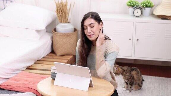 在家工作亚洲女性用一台笔记本电脑在在线视频电话会议上与一组同事一起工作和聊天