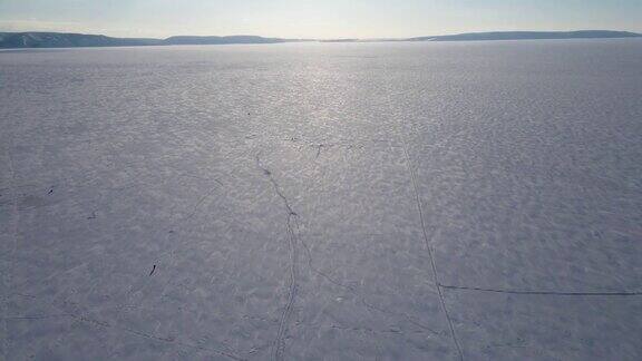 在阿拉斯加结冰的冬季河流上的渔民的鸟瞰图