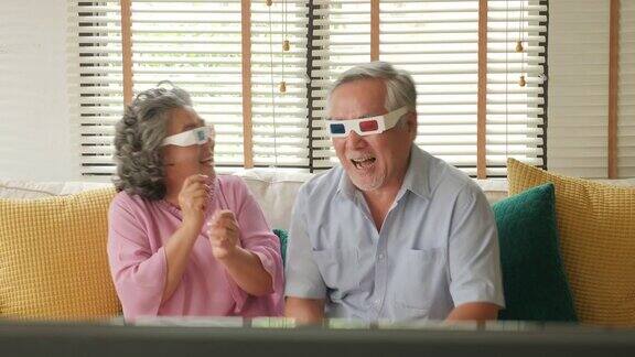 一对亚洲老年夫妇戴着3d眼镜在客厅一起跳舞人们以放松、养老、退休、高级生活方式为家庭观念