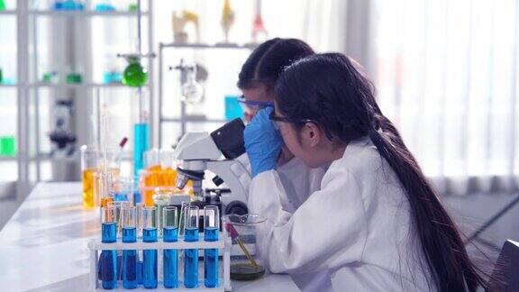 两名亚洲女孩私立小学的STEM学生进行科学实验