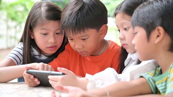 一大群年轻的男孩和女孩共享平板电脑和智能手机技术