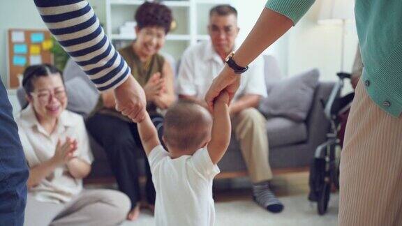 亚洲父母牵着宝宝的手走到爷爷奶奶家幸福的大家庭理念