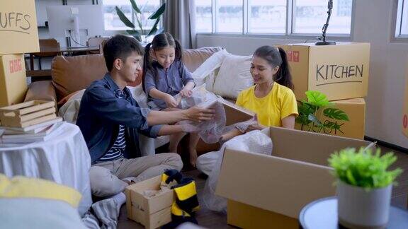 搬家亚洲家庭放松休闲的时间坐在一起与纸箱和东西爸爸妈妈女儿花时间在一起收拾东西家具为家公寓搬家