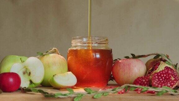 蜂蜜慢慢倒入玻璃罐中苹果和石榴即食