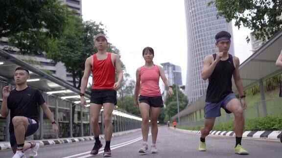 一群亚洲华人一起做弓步慢跑前做热身运动