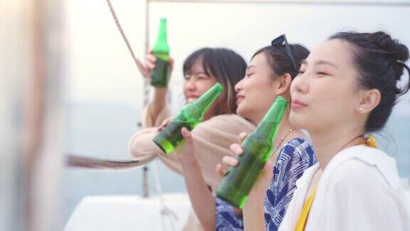 4K一群亚洲女性朋友一起在日落时分的海上豪华游艇上喝啤酒