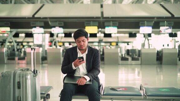 商人在机场等候时使用手机