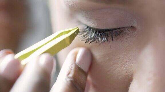 一个特写一个美容师小心地把个人睫毛到一个模特的眼睛