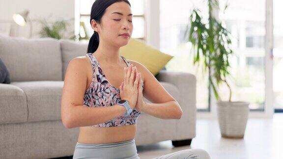 合十双手瑜伽和女人祈祷在客厅平静和平和正念健身和整体冥想冥想祈祷之手和精神亚洲人在休息室进行健康训练