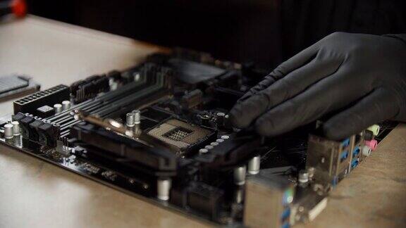 工程师修理工手握黑手套将芯片处理器CPU插入电脑或笔记本电脑的插座关闭视图