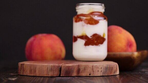 成熟的桃子放在木板上旁边是桃子味的酸奶