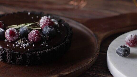 挞巧克力芝士蛋糕与新鲜浆果美味的生日甜点以木桌为背景