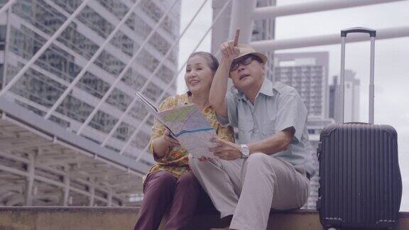 亚洲老年夫妇拿着地图搜索泰国的目的地街道退休年龄的老年人用自己的储蓄旅行旅行者和生活方式的老概念