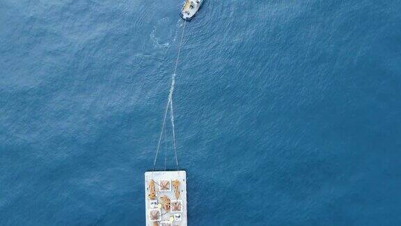用拖船拖着施工设备的浮动驳船俯视的无人机视图