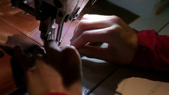 女性用老式缝纫机手工缝制皮革制品特写